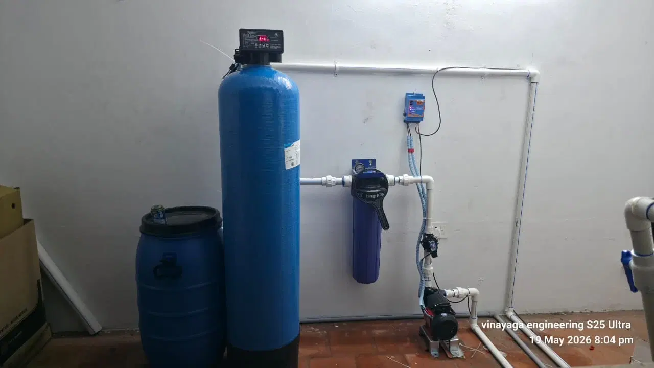 Domestic ion-exchange water softener system installed neatly in utility area with copper pipes